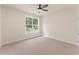 Bedroom with plush carpeting, ceiling fan, and large window overlooking a lawn at 348 Autumn Pheasant Loop, Calabash, NC 28467