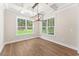 Bright dining room featuring new light fixture, hardwood floors, and large windows at 348 Autumn Pheasant Loop, Calabash, NC 28467