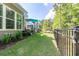 Expansive backyard with lush lawn, mature trees, and black fence for outdoor living at 402 Bumble Circle, Murrells Inlet, SC 29576