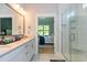 Modern bathroom with double vanity, glass shower, and view into the adjacent bedroom at 402 Bumble Circle, Murrells Inlet, SC 29576