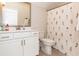 Well-lit bathroom features stylish floral shower curtain, white vanity, and plenty of counter space at 402 Bumble Circle, Murrells Inlet, SC 29576