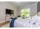 Bright bedroom boasts a TV, light wood floors, and large window for viewing the trees at 402 Bumble Circle, Murrells Inlet, SC 29576