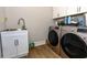 Functional laundry room with modern washer and dryer, sink, and cabinet for storage at 402 Bumble Circle, Murrells Inlet, SC 29576