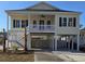 Charming yellow two-story house with a porch, dark shutters, and a spacious carport at 4831 Riverside Dr., North Myrtle Beach, SC 29582