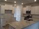 Modern kitchen with white cabinets, granite countertops, and stainless steel appliances at 8723 Baton Rouge Ave Nw, Calabash, NC 28467