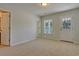 Neutral bedroom with carpet, a window, and a door to the exterior and attached bathroom at 8743 Baton Rouge Ave Nw, Calabash, NC 28467