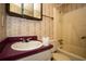 A bathroom featuring floral wallpaper, a bathtub, and sink, highlighting the fixtures and design elements at 1001 Creel St., Conway, SC 29527