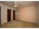 A bedroom with neutral walls, a ceiling fan, and two closet doors, showcasing the room's layout and features at 1001 Creel St., Conway, SC 29527