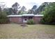 Charming single-story brick home featuring a metal roof, red trim, and a cozy front porch entrance at 1001 Creel St., Conway, SC 29527