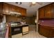 A view of the kitchen area featuring wooden cabinets, appliances, and a glimpse into the adjacent living space at 1001 Creel St., Conway, SC 29527