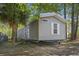 Cozy gray mobile home on a tree-filled lot, featuring light-filled windows and a charming outdoor atmosphere at 103 Off Shore Dr., Murrells Inlet, SC 29576