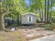 Gray mobile home on a tree-filled lot, offering light-filled windows and a cozy atmosphere for simple living at 103 Off Shore Dr., Murrells Inlet, SC 29576