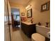 Neat bathroom features a dark vanity, framed mirror, with convenient access to other rooms in the house at 106 Jessamine St., Andrews, SC 29510