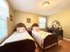 Cozy bedroom featuring two twin beds with matching quilts and wooden headboards plus a wooden vanity at 106 Jessamine St., Andrews, SC 29510
