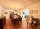 Well-lit dining room with a chandelier, wood floors, and a view into a bright and airy kitchen at 106 Jessamine St., Andrews, SC 29510