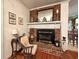 Cozy living space features a brick fireplace with mantel, chair, and wood flooring for a warm, inviting atmosphere at 106 Jessamine St., Andrews, SC 29510