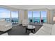 Bright living room with balcony access and ocean views features modern white furniture and gray carpeting at 107 S Ocean Blvd. # 1201, Myrtle Beach, SC 29577