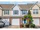 Charming townhome featuring brick accents, a one-car garage, and a blue front door surrounded by mature landscaping at 1098 Stanton Pl., Myrtle Beach, SC 29579