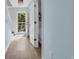 Hallway with wood floors leading to exterior view, showcasing natural light and layout to bathroom and stairs at 1098 Stanton Pl., Myrtle Beach, SC 29579