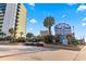 Beautiful condo building entrance with parking and lush tropical landscaping at 1105 S Ocean Blvd. # 422, Myrtle Beach, SC 29577