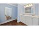 Bathroom features double sink vanity, a large mirror, with blue walls and hardwood floors at 1114 S Dogwood Dr., Surfside Beach, SC 29575