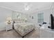 Bright bedroom with stylish furnishings, including a queen bed, lamps, and a wicker side table at 1114 S Dogwood Dr., Surfside Beach, SC 29575