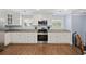 Well-lit kitchen featuring stainless steel appliances, granite countertops, ample cabinet space and hardwood floors at 1114 S Dogwood Dr., Surfside Beach, SC 29575