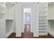 Spacious walk-in closet featuring custom shelving and hardwood floors leading to the main bathroom at 1114 S Dogwood Dr., Surfside Beach, SC 29575