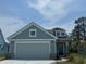 Charming home with a two-car garage, blue siding, brick detail and a manicured lawn at 1233 Lady Bird Way, North Myrtle Beach, SC 29582