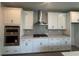 Modern kitchen featuring stainless steel appliances, stylish gray backsplash, and white cabinetry at 1233 Lady Bird Way, North Myrtle Beach, SC 29582