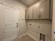 Laundry room with tile floors and overhead cabinets at 1233 Lady Bird Way, North Myrtle Beach, SC 29582