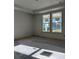 Sunlit bedroom with unfinished floors, two large windows overlooking a tranquil outdoor setting, and natural wood trim at 1249 Lady Bird Way, North Myrtle Beach, SC 29582
