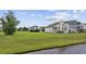 Spacious backyard with a well-manicured lawn, mature tree, and a view of the neighborhood pond at 1315 Ashboro Ct., Myrtle Beach, SC 29579