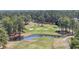 Aerial view of golf course with pond and golf carts meandering around the green at 136 Regency Dr., Conway, SC 29526