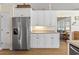 Bright kitchen features white cabinets, stainless steel refrigerator, and seamless access to an adjacent living room at 136 Regency Dr., Conway, SC 29526