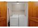 Laundry room featuring full-sized washer and dryer behind wood-paneled folding doors at 138 Lumbee Circle # 17, Pawleys Island, SC 29585