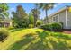 Spacious backyard with a patio, green umbrella, mature trees, and well-maintained landscaping at 141 Wickham Ct., Pawleys Island, SC 29585