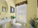Bathroom featuring a pedestal sink, decorative window treatment, and patterned wall art at 141 Wickham Ct., Pawleys Island, SC 29585