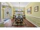 Inviting dining room with hardwood floors, decorative wainscoting, and stylish chandelier over a glass table at 141 Wickham Ct., Pawleys Island, SC 29585
