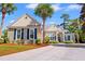 Charming single-story home with manicured landscaping, palm trees, and a concrete driveway under a sunny sky at 141 Wickham Ct., Pawleys Island, SC 29585