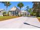 Inviting one-story home featuring a well-manicured lawn, tall palms, and a wide concrete driveway at 141 Wickham Ct., Pawleys Island, SC 29585