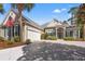 Beige single-story home with an attached two-car garage and landscaped yard with blue shutters at 141 Wickham Ct., Pawleys Island, SC 29585