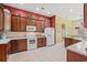 Well-maintained kitchen with brown cabinets, white appliances, tile floors, and solid surface countertops at 141 Wickham Ct., Pawleys Island, SC 29585