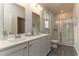 Well-lit bathroom featuring double sinks, a large mirror, and a glass-enclosed shower for a spa-like experience at 1439 Nokota Dr., Conway, SC 29526