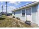 Charming guest house exterior featuring light blue siding, a white door, and landscaped surroundings at 1512 S Ocean Blvd., North Myrtle Beach, SC 29582