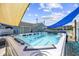 This backyard features a modern hot tub with water and lounge chairs under a shade sail at 1512 S Ocean Blvd., North Myrtle Beach, SC 29582