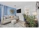 Comfortable living room with a sofa, ottoman, TV, decorative clock, and a glimpse into the bathroom at 1512 S Ocean Blvd., North Myrtle Beach, SC 29582