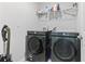 Bright laundry room featuring gray, front-load Samsung washer and dryer, overhead wire shelving, and gray flooring at 154 Seasons Trace Loop, Longs, SC 29568