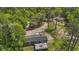 Aerial shot of cozy home with wooden deck, nestled amongst tall trees with a red car parked nearby at 1651 Weldon Ln., Conway, SC 29526