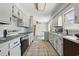 Kitchen with white cabinets, black appliances, and a connecting bar overlooking an adjacent room at 1651 Weldon Ln., Conway, SC 29526